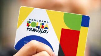 A imagem mostra uma criança segurando o cartão do Bolsa Família