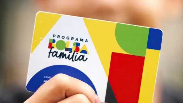 A imagem mostra uma criança segurando o cartão do Bolsa Família