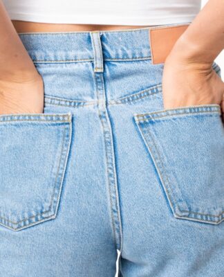 Mulher de costas vestindo calça jeans com as mãos no bolso