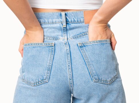 Mulher de costas vestindo calça jeans com as mãos no bolso