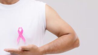 Homem segurando uma fitinho de outubro rosa