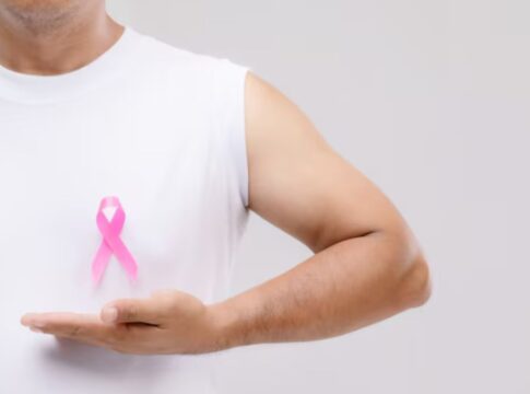 Homem segurando uma fitinho de outubro rosa