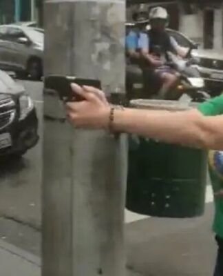 Parlamentar Carla Zambelli (PL-SP), em 2022, empunhando e apontando uma arma na rua