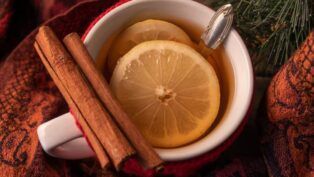 Xícara com chá de canela com rodelas de limão