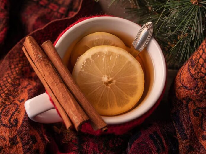 Xícara com chá de canela com rodelas de limão