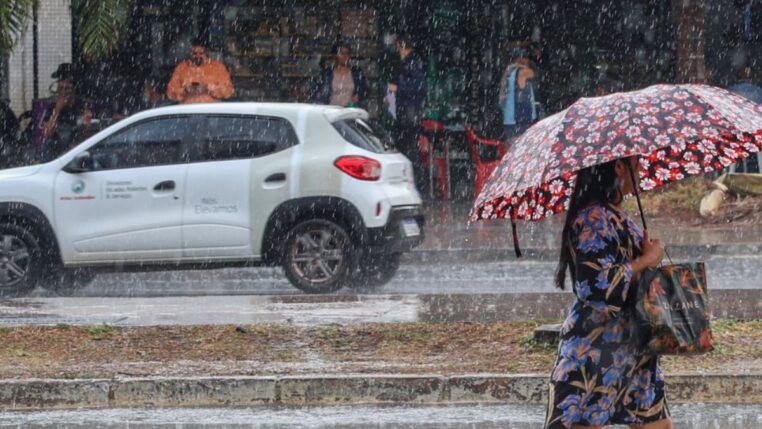 Mulher andando na chuva com guarda-chuva