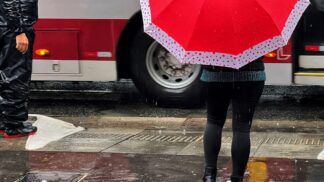 Pessoas andando na Avenida Paulista com guarda-chuva durante temporal