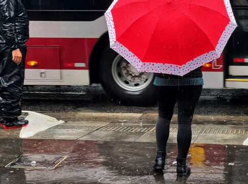 Pessoas andando na Avenida Paulista com guarda-chuva durante temporal