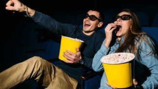 Homem e mulher comendo pipoca no cinema