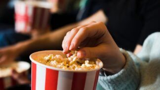 Pessoa comendo pipoca no cinema