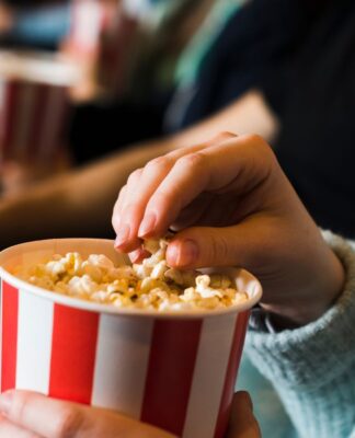 Pessoa comendo pipoca no cinema