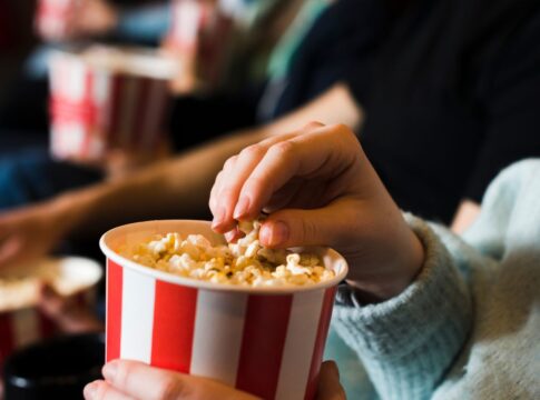 Pessoa comendo pipoca no cinema