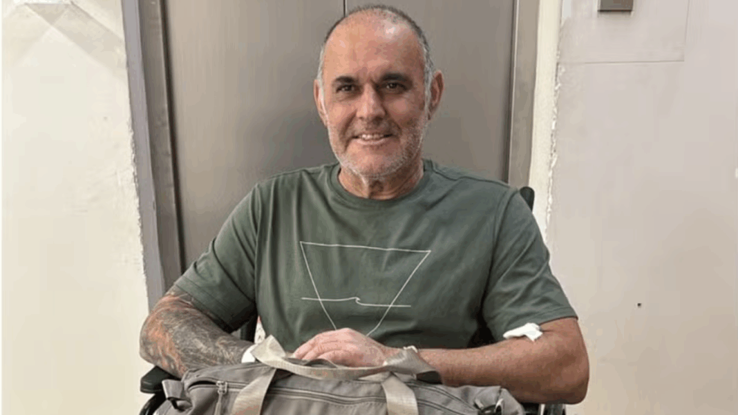 Cláudio Crespi sentado em uma cadeira de rosas