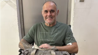 Cláudio Crespi sentado em uma cadeira de rosas