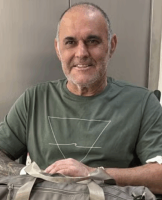 Cláudio Crespi sentado em uma cadeira de rosas