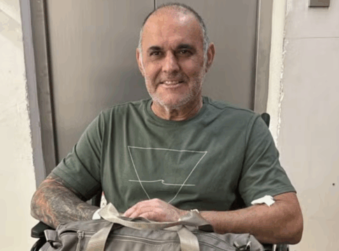 Cláudio Crespi sentado em uma cadeira de rosas