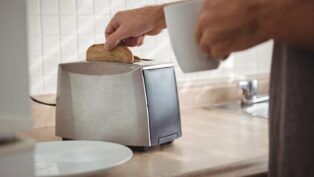 Homem tirando pão da torradeira