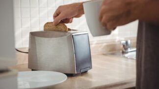 Homem tirando pão da torradeira