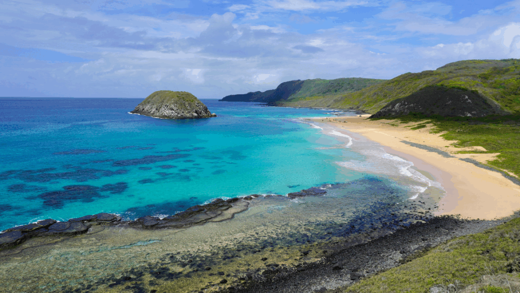 Vista aérea do Parque Nacional Marinho de Fernando de Noronha, em Pernambuco. Mar com vários tons de azul.