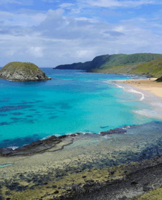 Vista aérea do Parque Nacional Marinho de Fernando de Noronha, em Pernambuco. Mar com vários tons de azul.