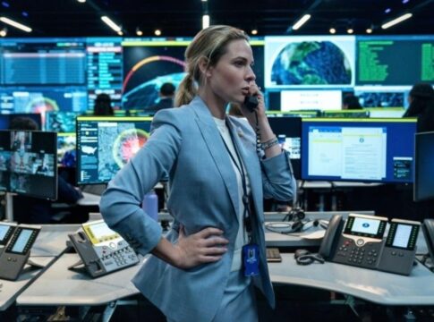 Imagem colorida de mulher em sala com computadores