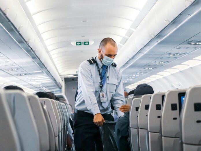 Imagem colorida de comissário de bordo homem em um avião