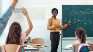 Imagem colorida de professora e alunos em sala de aula