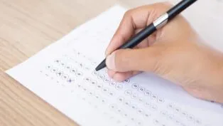 Imagem colorida de pessoa assinalando gabarito