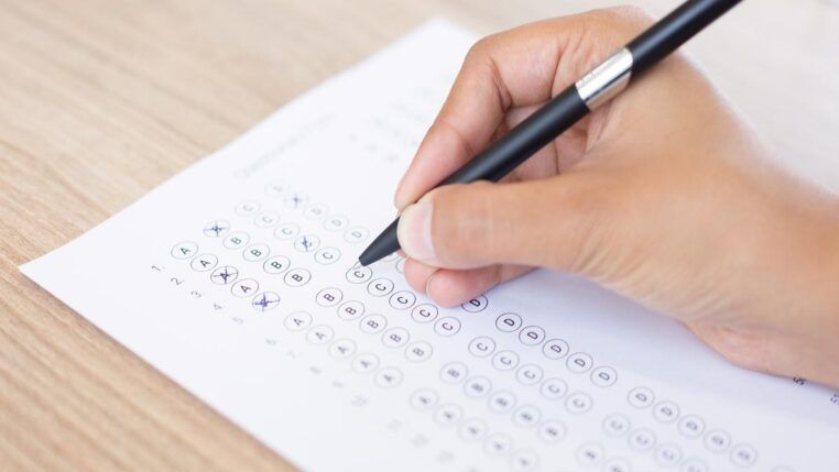 Imagem colorida de pessoa assinalando gabarito