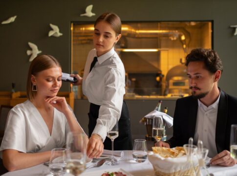 Garçonete servindo uma mesa com casal