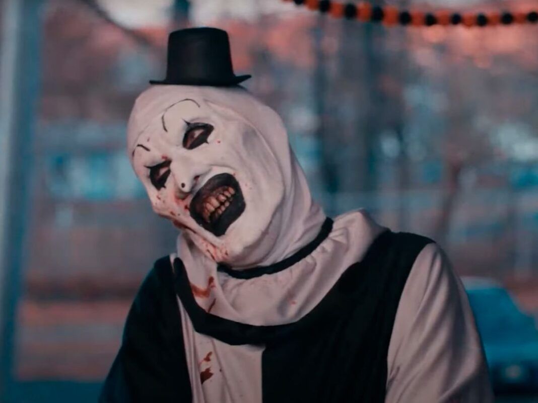 Homem vestido de palhaço com maquiagem branca e batom preto.