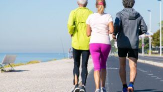 Idosos correndo em pista ao lado da praia