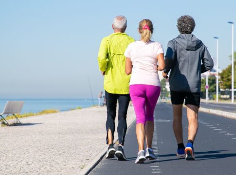 Idosos correndo em pista ao lado da praia