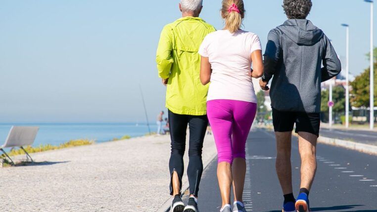 Idosos correndo em pista ao lado da praia