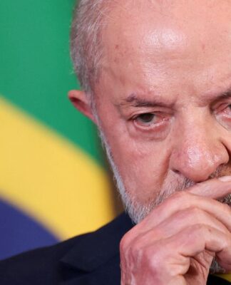 Uma foto em close-up (plano detalhe) que foca no rosto e na expressão do presidente Luiz Inácio Lula da Silva. A imagem é cortada logo abaixo do nariz e acima da testa, concentrando-se na face.