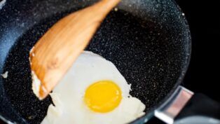 Pessoa fritando ovo na frigideira