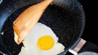 Pessoa fritando ovo na frigideira