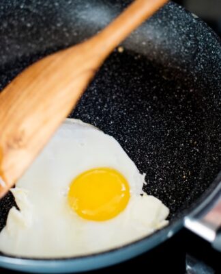 Pessoa fritando ovo na frigideira