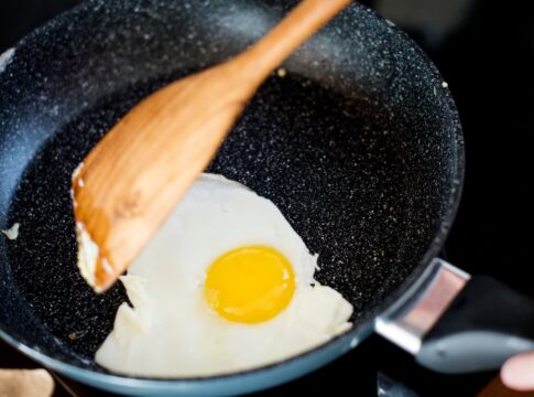 Pessoa fritando ovo na frigideira