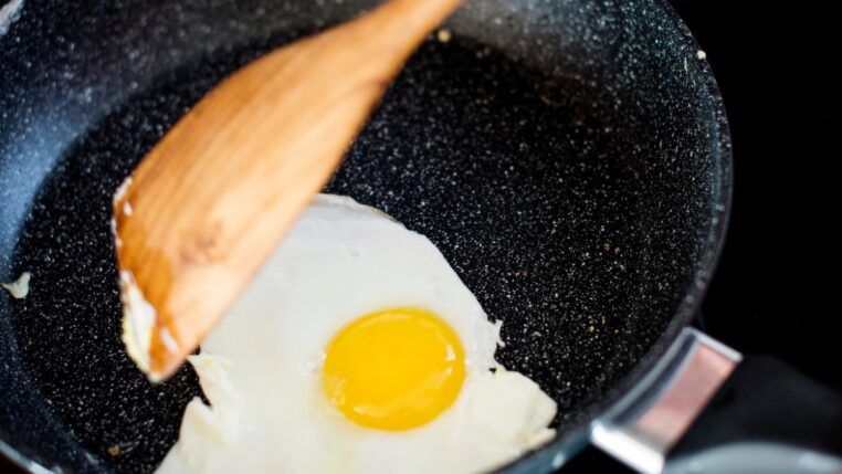 Pessoa fritando ovo na frigideira