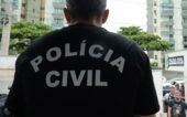 Imagem de um policial de costas com uma camisa preta. Na vestimenta, está escrito "Polícia Civil".