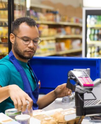 Atendente de supermercado passando produtos no caixa