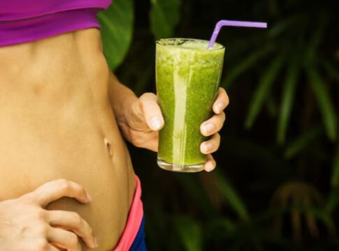 Barriga malhada e copo de suco vere detox