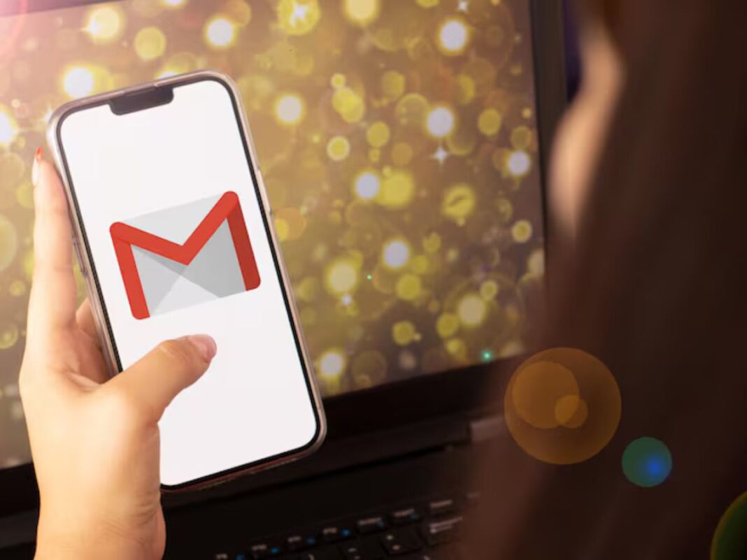Mão segurando o celular com o logo do Gmail