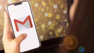 Mão segurando o celular com o logo do Gmail