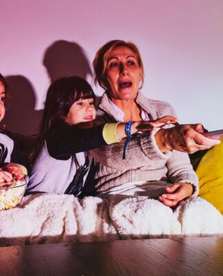 Em imagem ilustrativa, família se reúnem para assistir um filme