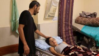 Pai cuidando do filho ferido em Gaza