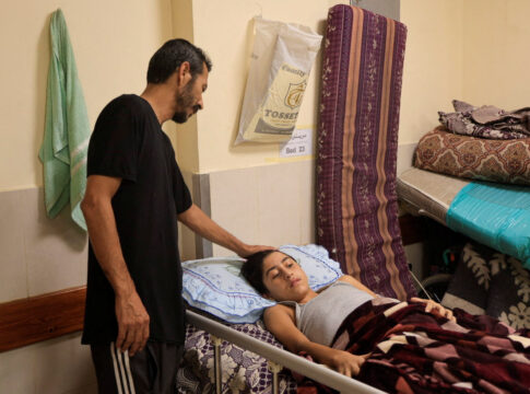 Pai cuidando do filho ferido em Gaza