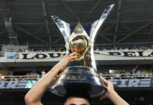 Troféu do Brasileirão Série A 2024 sendo segurado por mãos, sobre a cabeça de um atleta