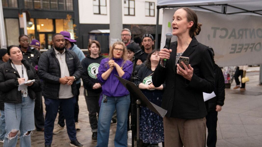 Mulher falando em palanque para outros trabalhadores do sindicato